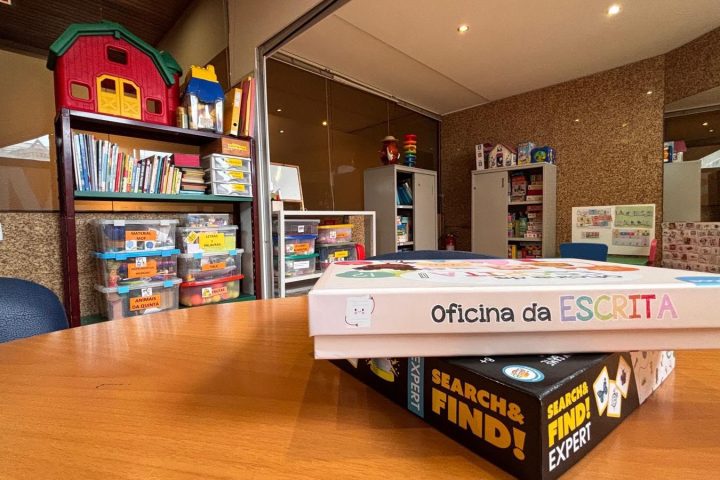 Jogos de escrita sobre a mesa e estante com materiais terapêuticos