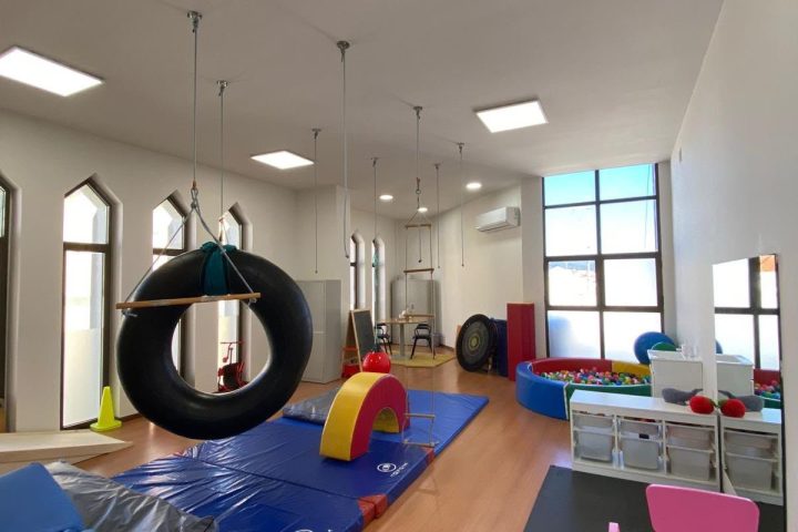 Sala de integração sensorial do MaisPessoa com baloiço de pneu, colchões e mesa para crianças
