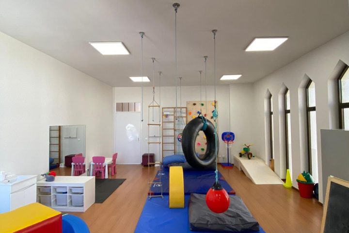 Vista geral da sala de integração sensorial, com baloiços, colchões e espaldar